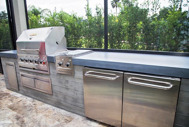 Canadian outdoor kitchen with bbq, access drawers, fridge and wood cladding.